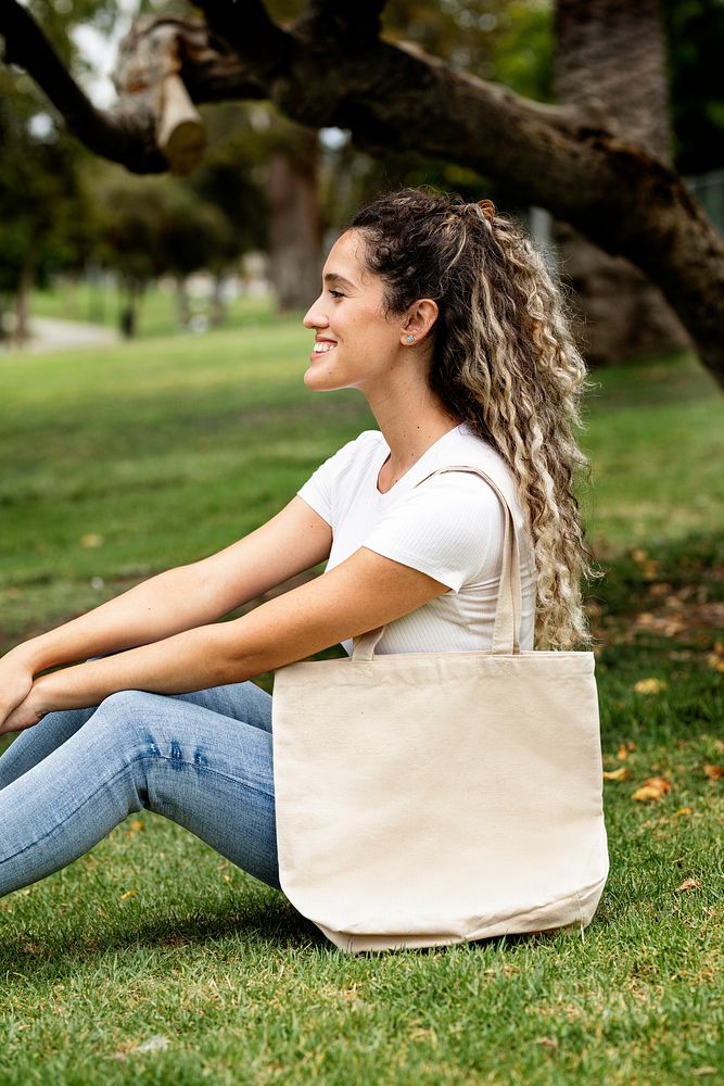 Woman with tote bag in a park, summer holiday