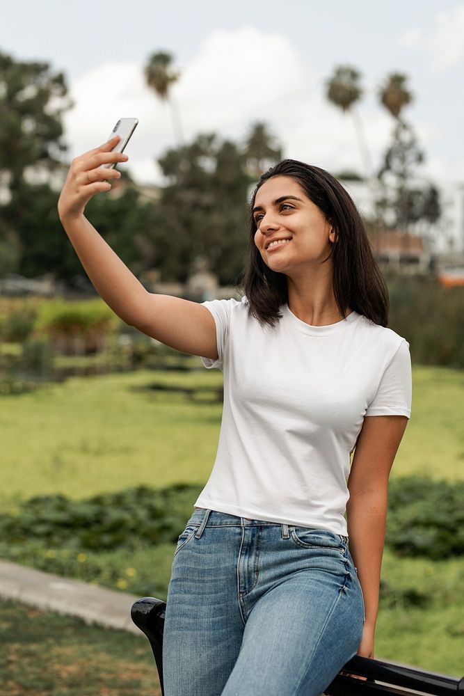 Hispanic woman in white tee, taking selfies, casual wear