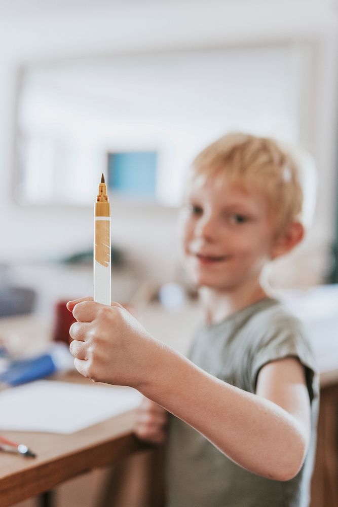 Boy with yellow color pen, homeschooling in the new normal
