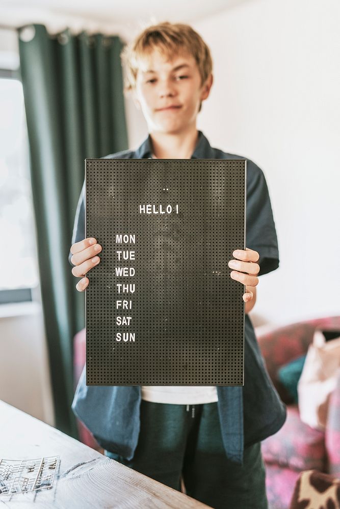 Boy showing black letter board, shop sign