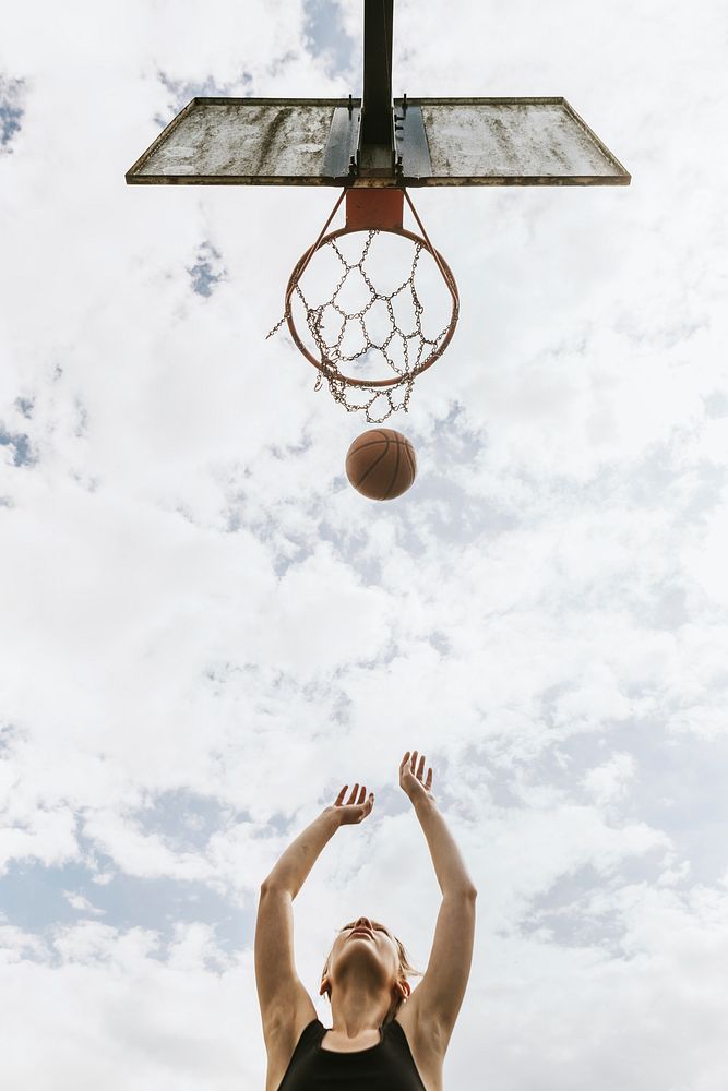 Sport background, young girl shooting a basketball, summer hobby