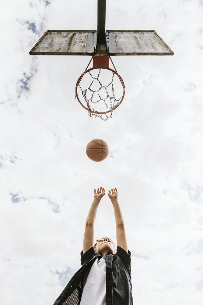 Sport background, young boy shooting a basketball, summer hobby