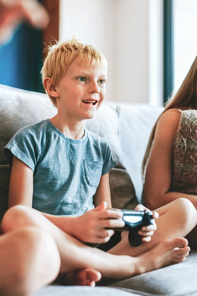 Blond boy playing video game in living room