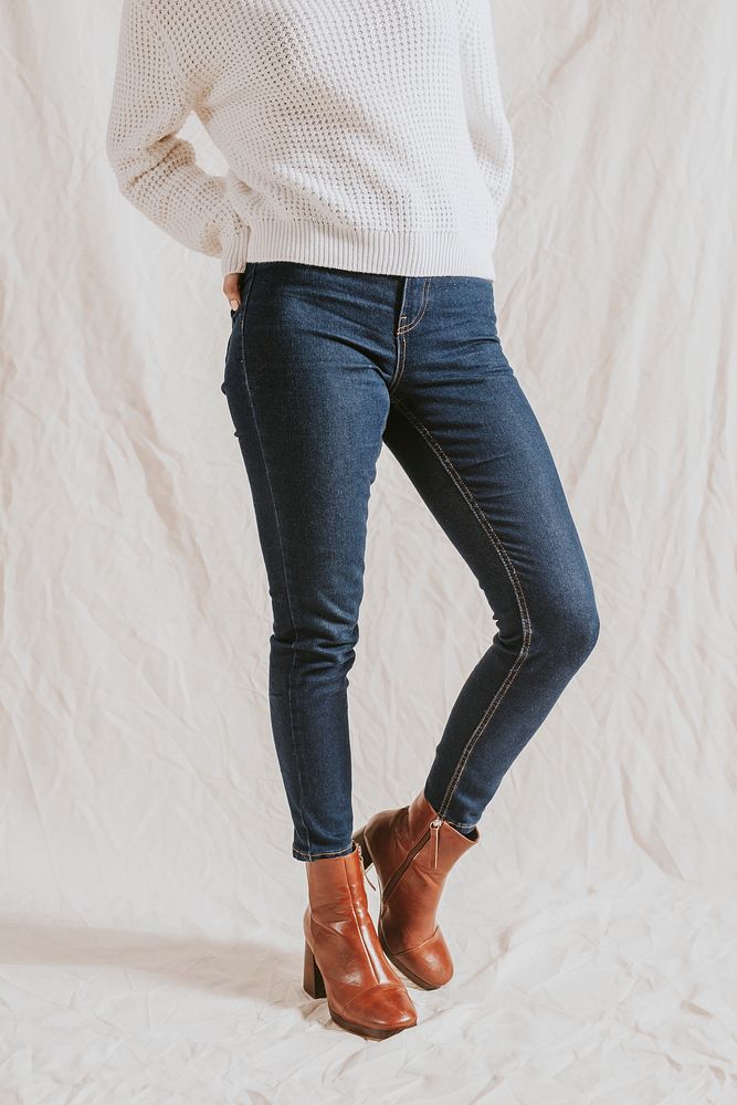 Woman in blue jeans and leather boots, half body