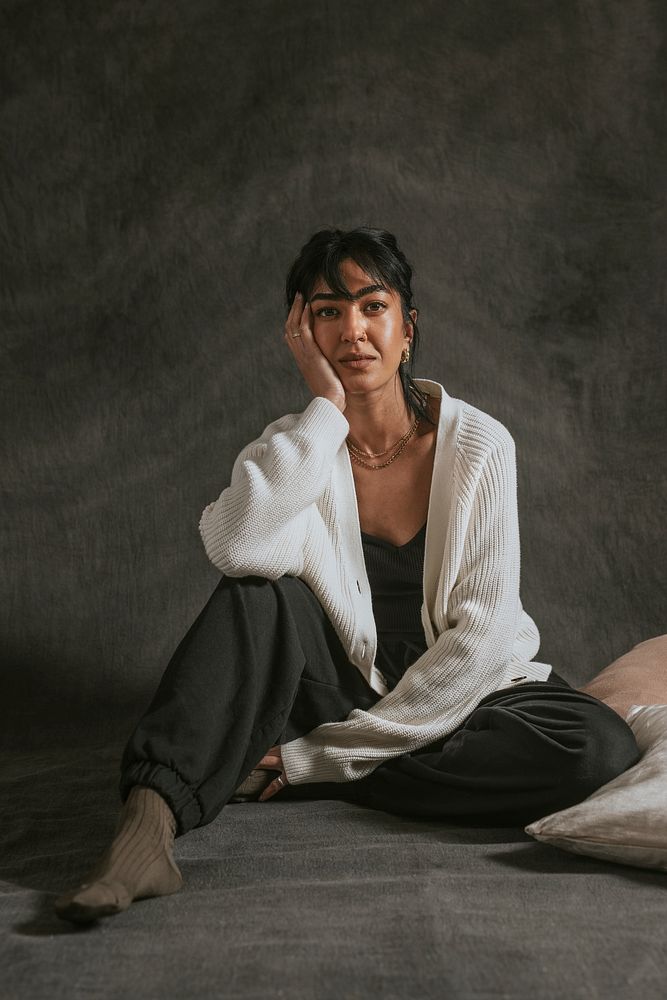 Asian woman in black sleepwear sitting on bed