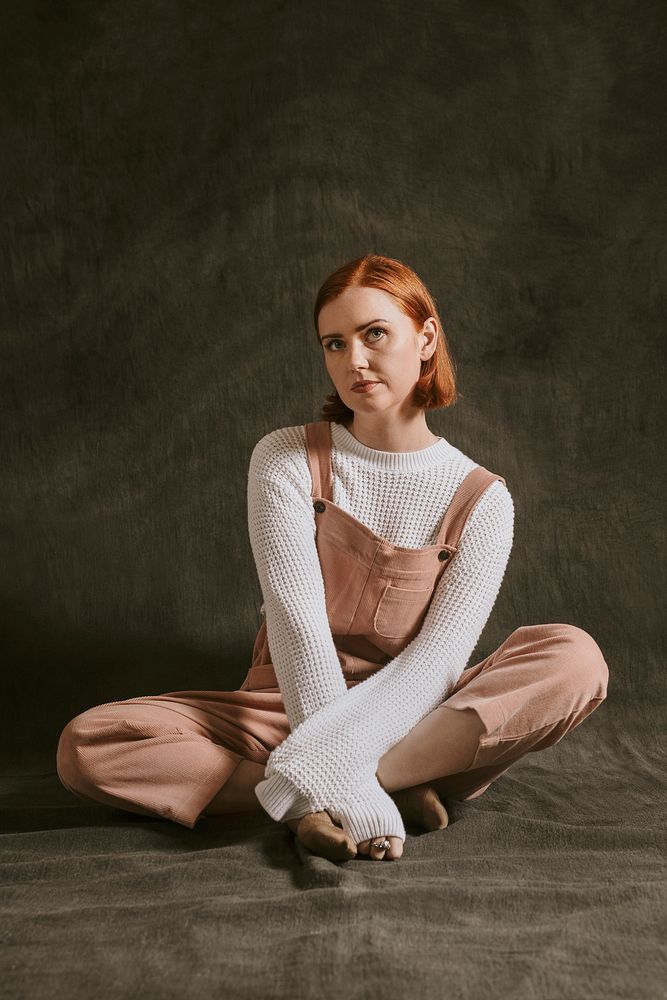 Woman wearing white sweater with pink overall