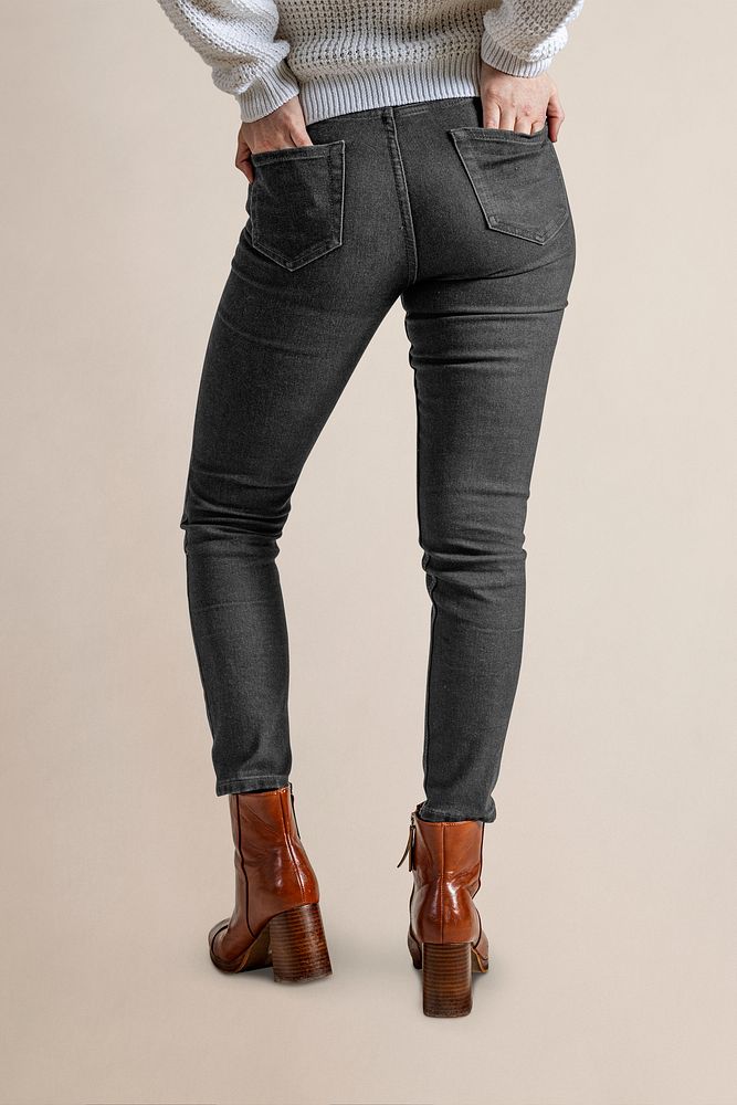 Woman in black jeans and leather boots, half body rear view