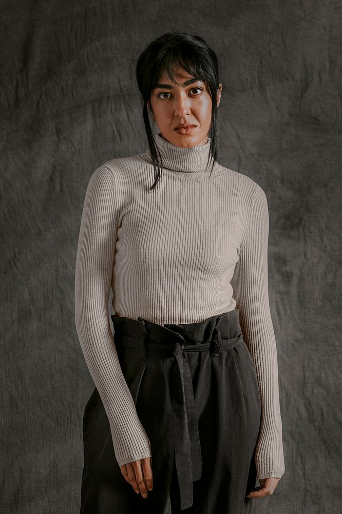 Woman wearing gray turtleneck sweater with black pants, autumn apparel fashion design