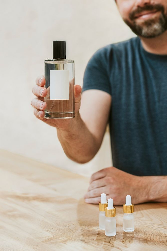 Man holding perfume bottle, beauty product design