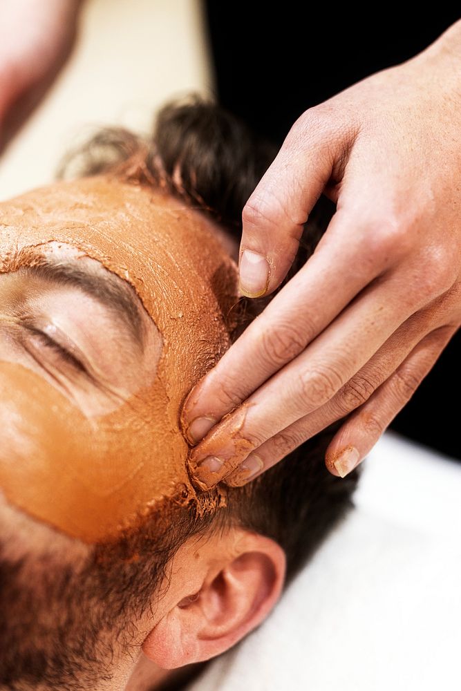 Man getting spa facial mask, self-care photo