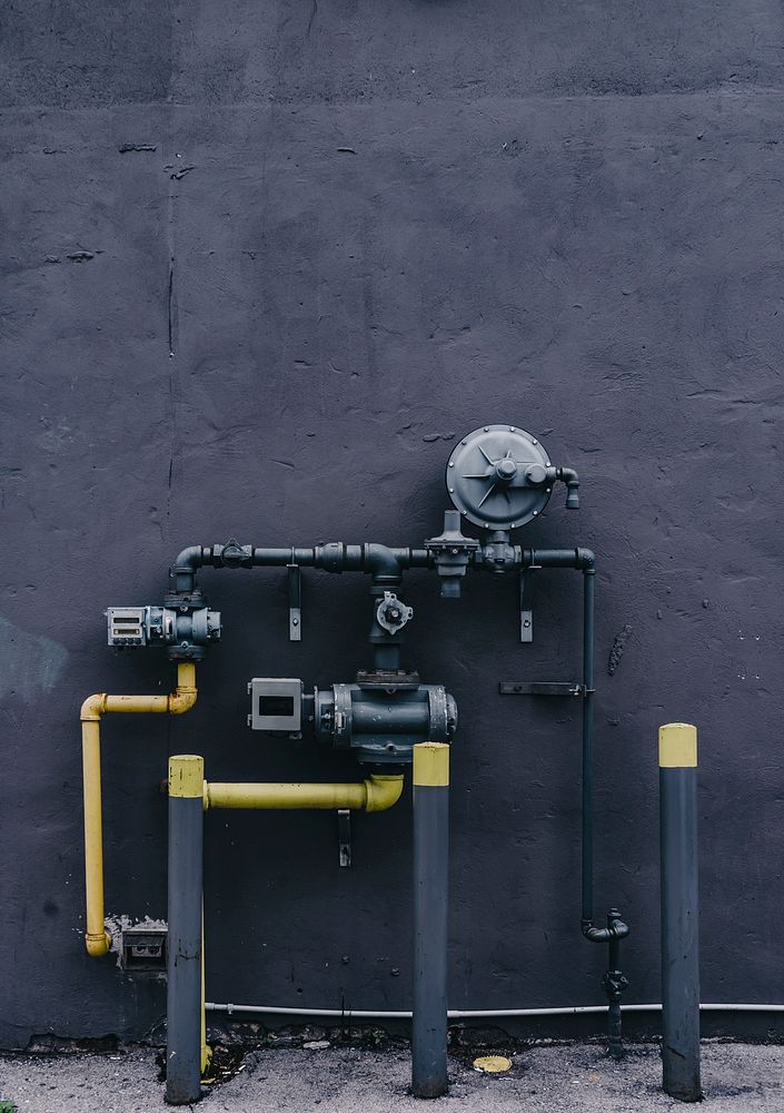 Pipes and meter on a gray wall