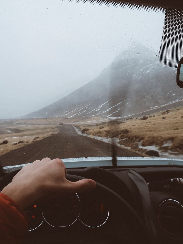 Man driving a car through rural Iceland