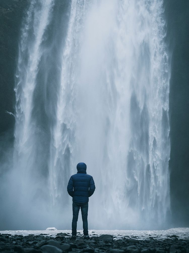 Man enjoying a view of Sk&oacute;gafoss waterfall in Iceland