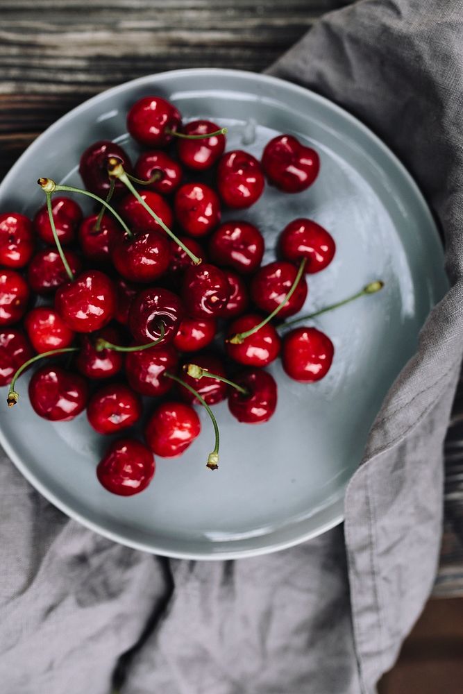 A plate with red cherries. Visit Kaboompics for more free images.