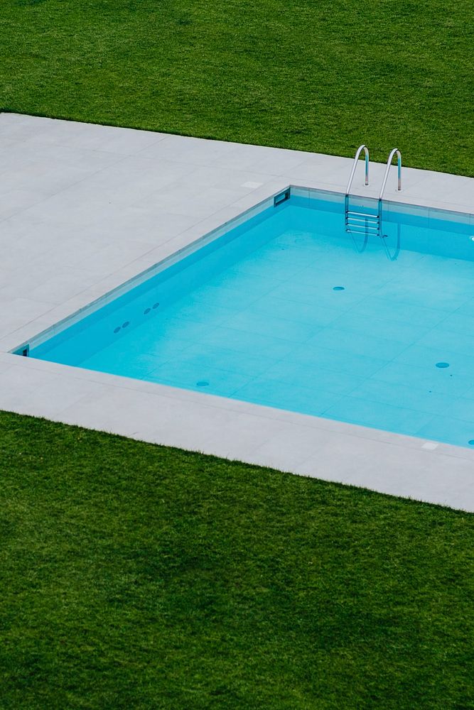 Swimming pool surrounded by green grass. Visit Kaboompics for more free images.