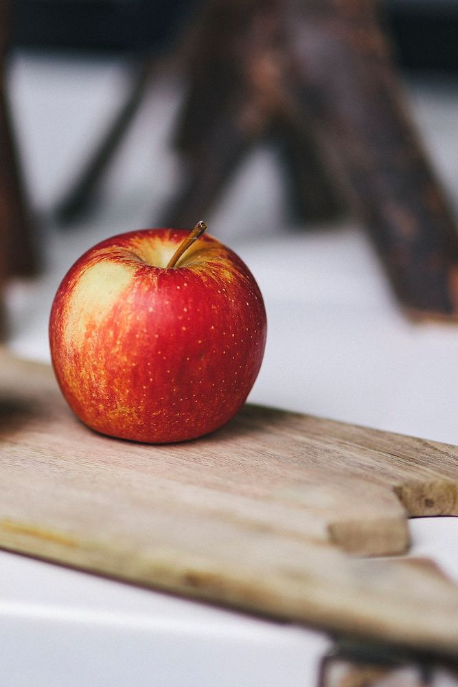 Fresh red apple on a cutting board. Visit Kaboompics for more free images.