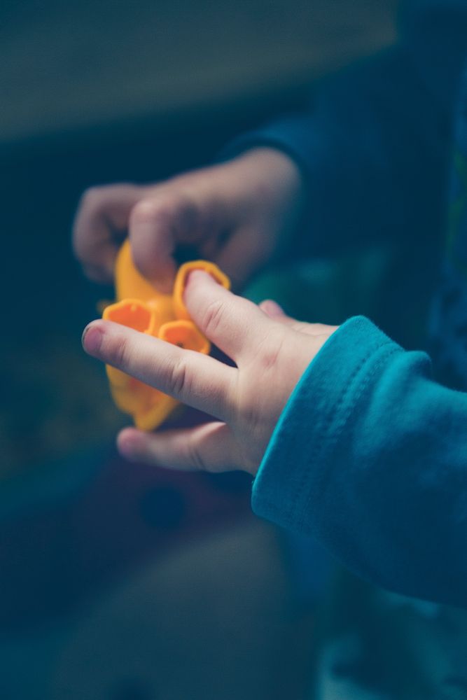 Kid playing with an orange toy