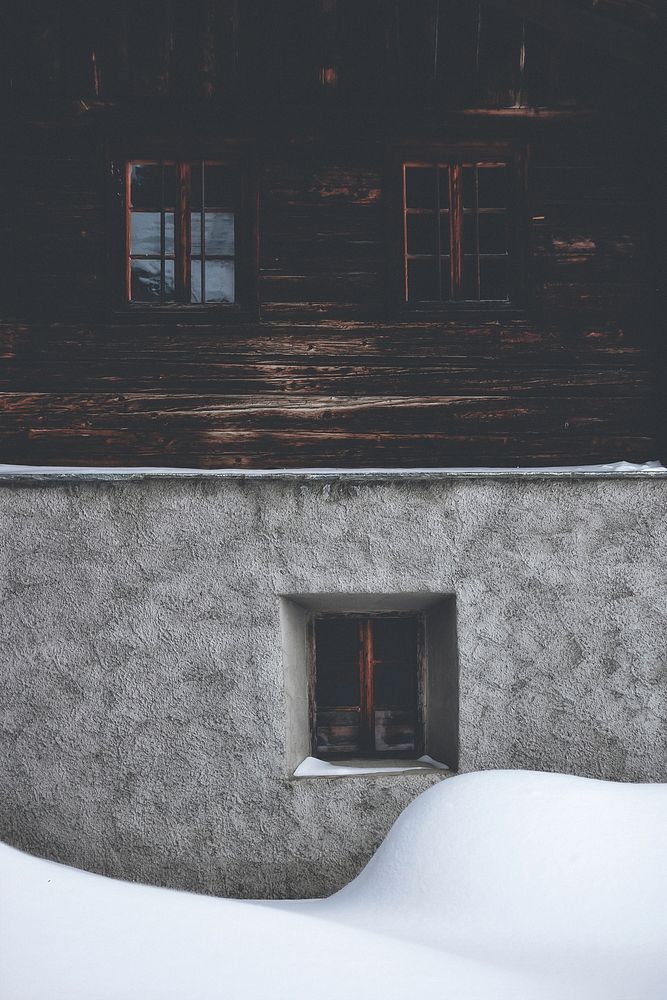 Snow covering a house with wooden windows