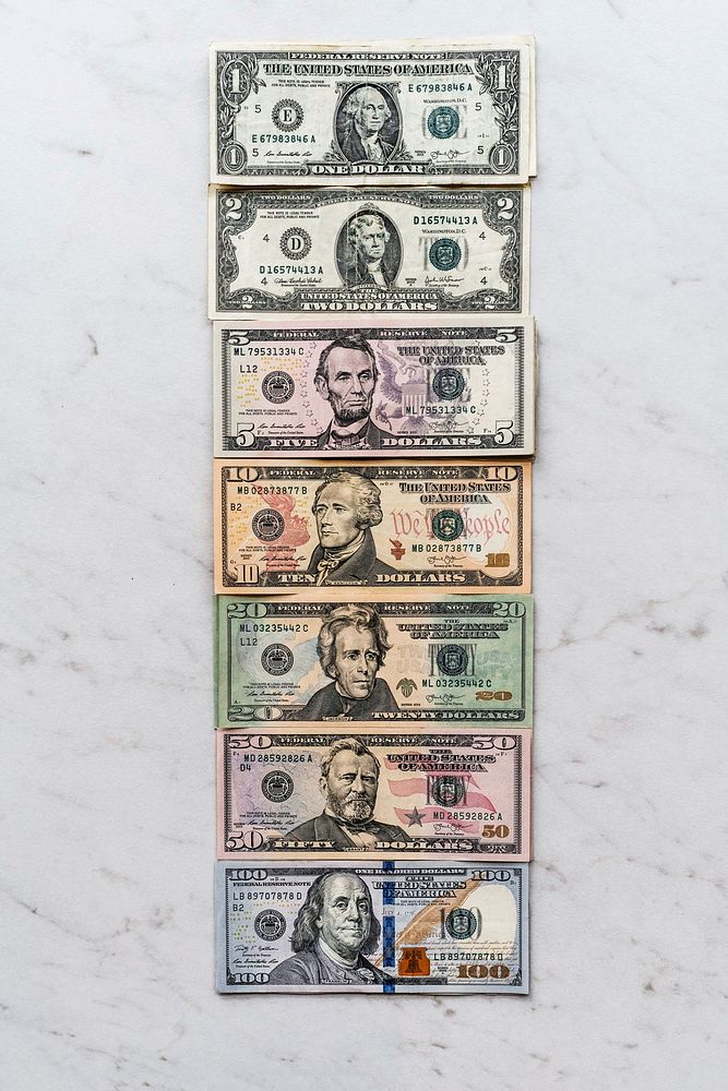 American paper money laid out vertically from small to large bills.