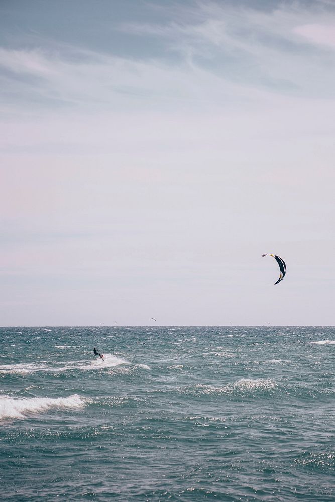 A kite surfer rides a wave.
