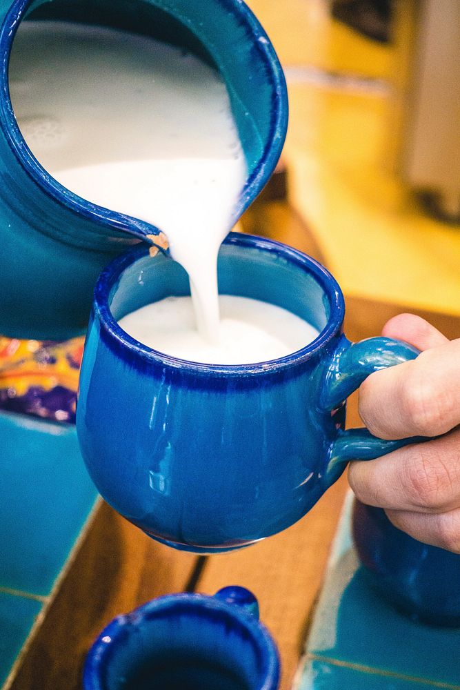 Free pouring yogurt drink into blue porcelain cup photo, public domain beverage CC0 image.