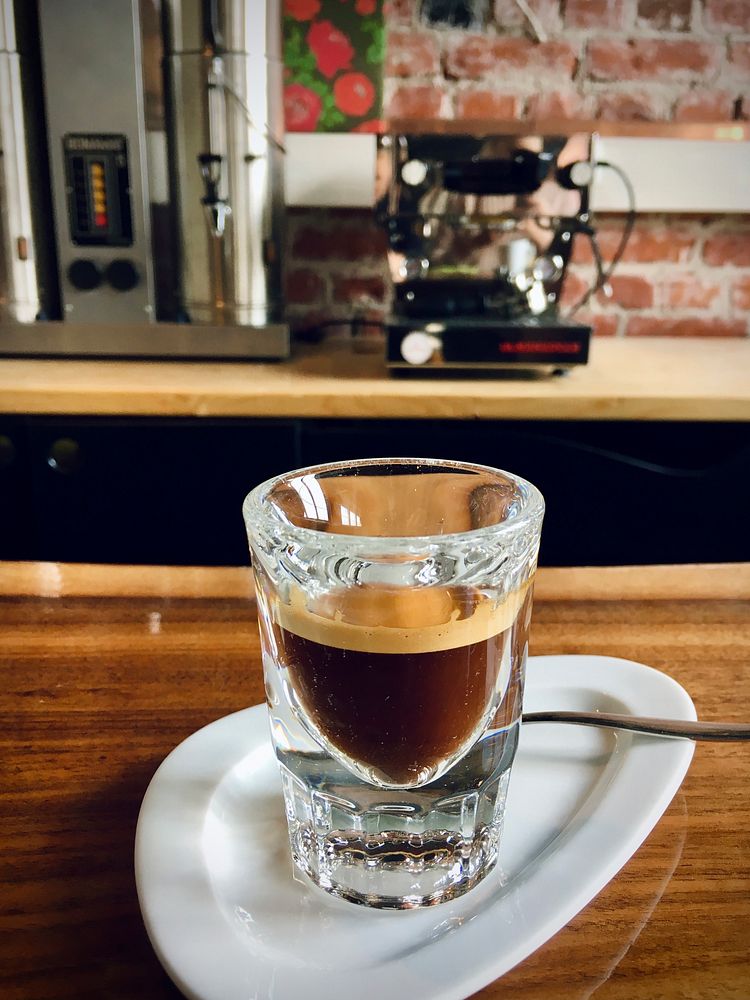 Free espresso on white saucer, wooden table photo, public domain beverage CC0 image.