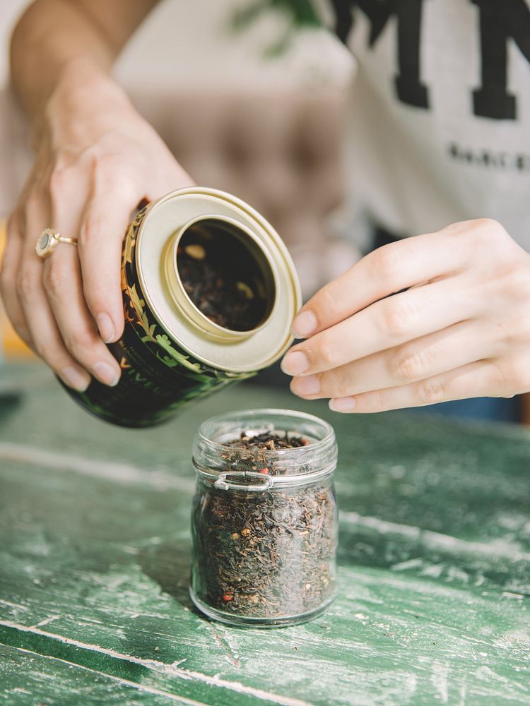 Free woman filling glass container with tea leafs image, public domain beverage CC0 photo.