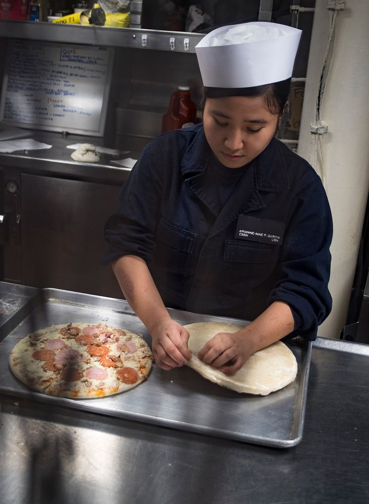 ATLANTIC OCEAN (April 14, 2018) Culinary Specialist Seaman Arianna Pascua prepares pizza for the evening meal aboard the…