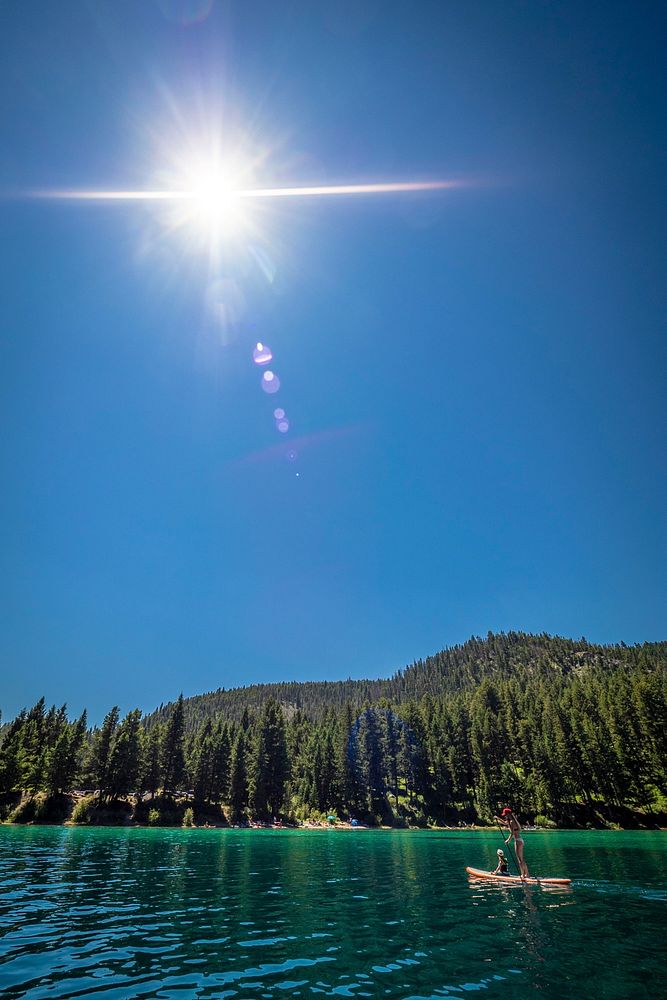 A woman paddle boards Wade Lake with her dog in the Beaverhead-Deerlodge National Forest.