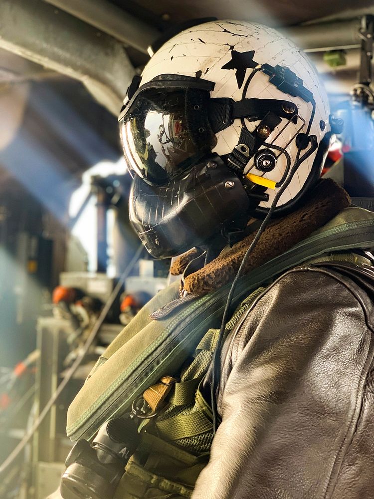 U.S. Navy Naval Aircrewman (Helicopter) 1st Class Aaron Leek, from Las Vegas, looks out of the door of an MH-60S Sea Hawk…