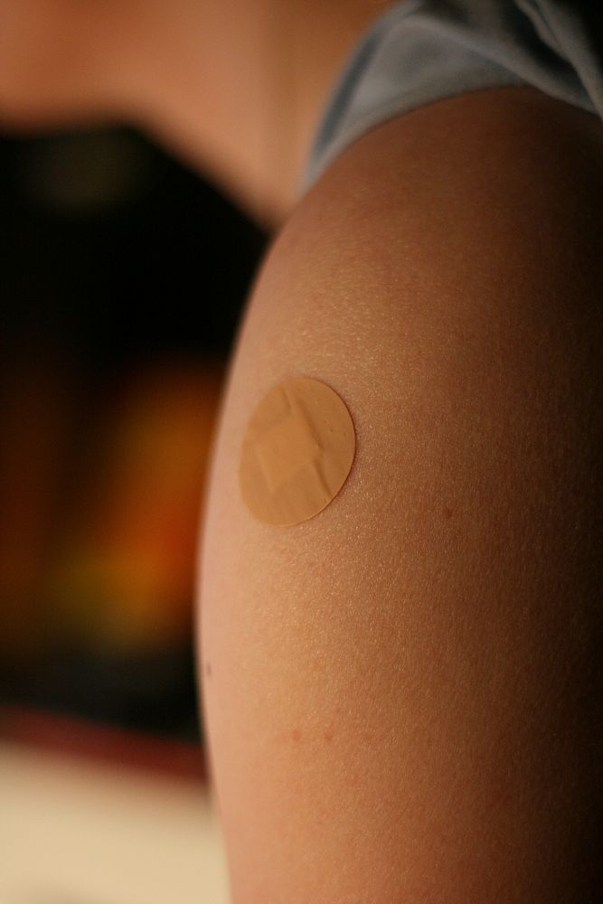 Vaccine bandage on women's arm. Original public domain image from Flickr