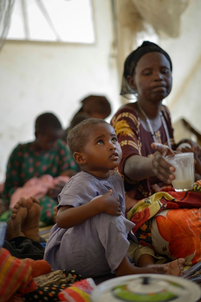 A young child receives a meal in a makeshift hospital erected at an AMISOM military camp to help those affected by recent…