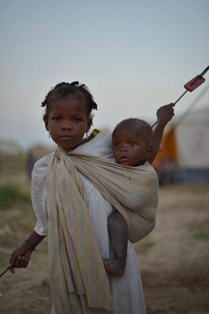 A young girl with her baby brother in an IDP camp near the town of Jowhar, Somalia, on December 14. Original public domain…