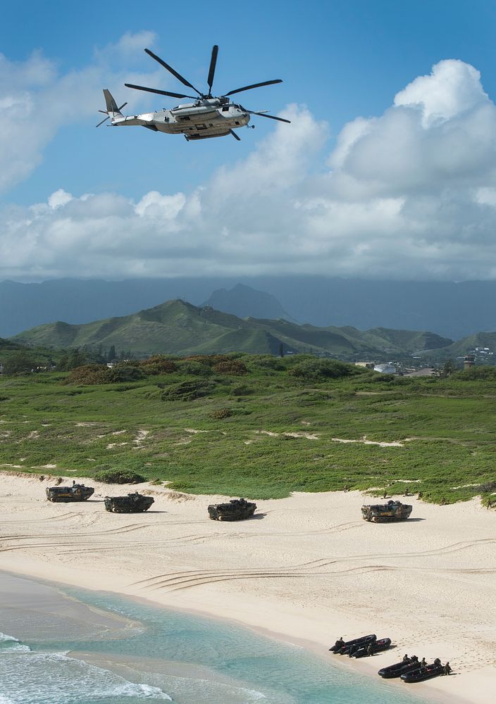 A U.S. Marine Corps CH-53E Super Stallion helicopter flies over a simulated amphibious beach assault during Rim of the…