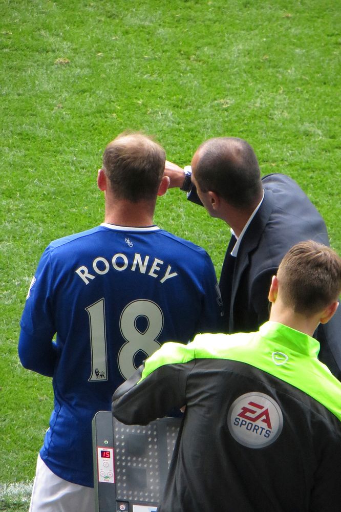 I Know His Name From Somewhere...Wayne Rooney pulls on the blue shirt again and takes some instruction from Roberto as he…