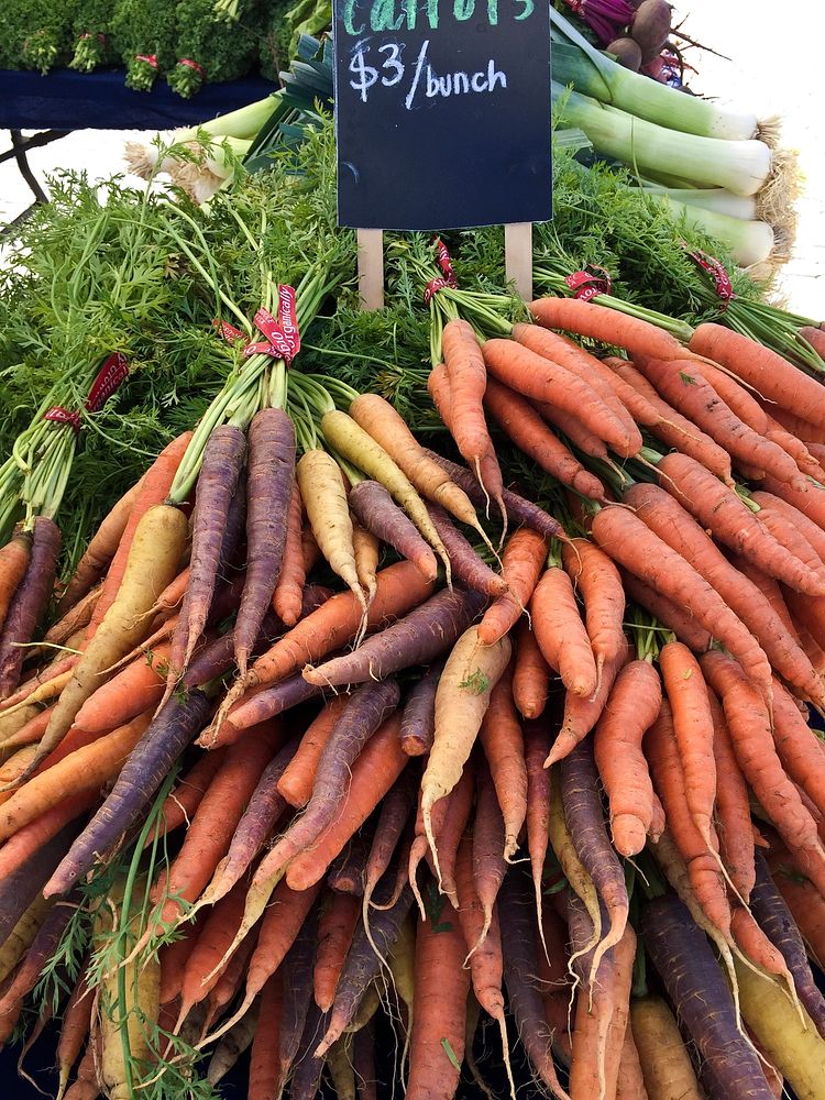 Purple, yellow and orange carrots and leeks, at the Jack London Square Farmers' Market in Oakland, CA, on Sunday, August 9…