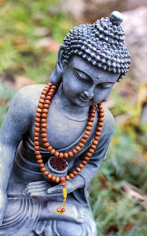 Buddha statue with beads. Free public domain CC0 image.