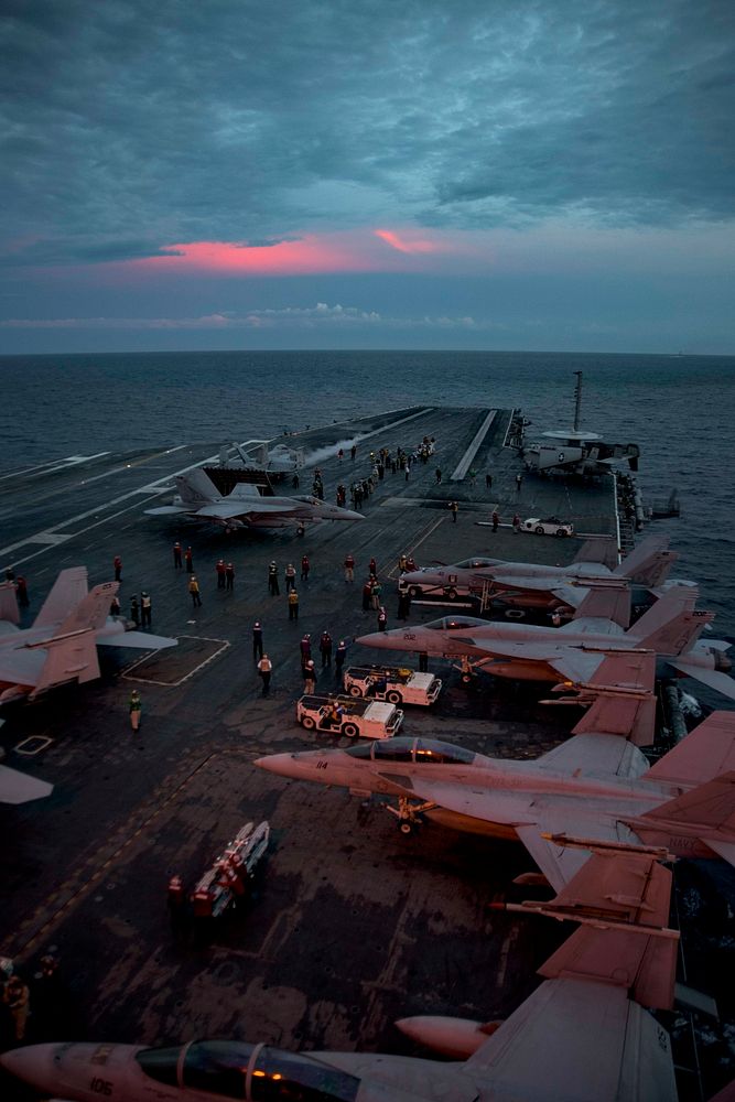 U.S. Navy Sailors prepare to conduct night flight operations on the flight deck of the aircraft carrier USS Dwight D.…