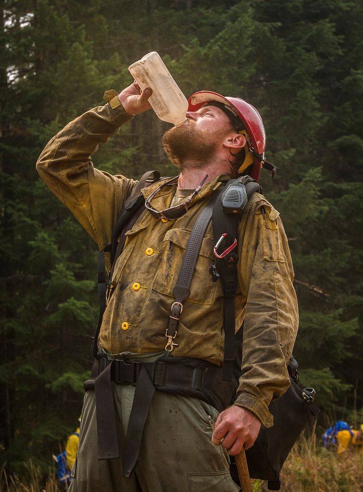 Zane Willert, a firefighter with the Devil's Canyon Handcrew, stays hydrated while supervising tactical training with the…