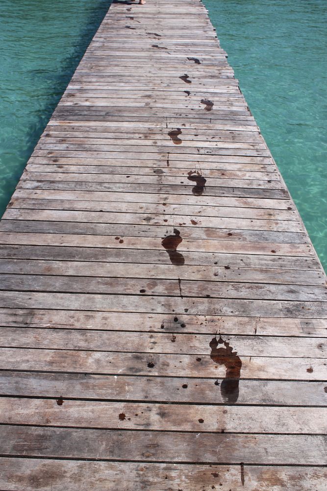 Wet footprints on wooden planks. Free public domain CC0 image.