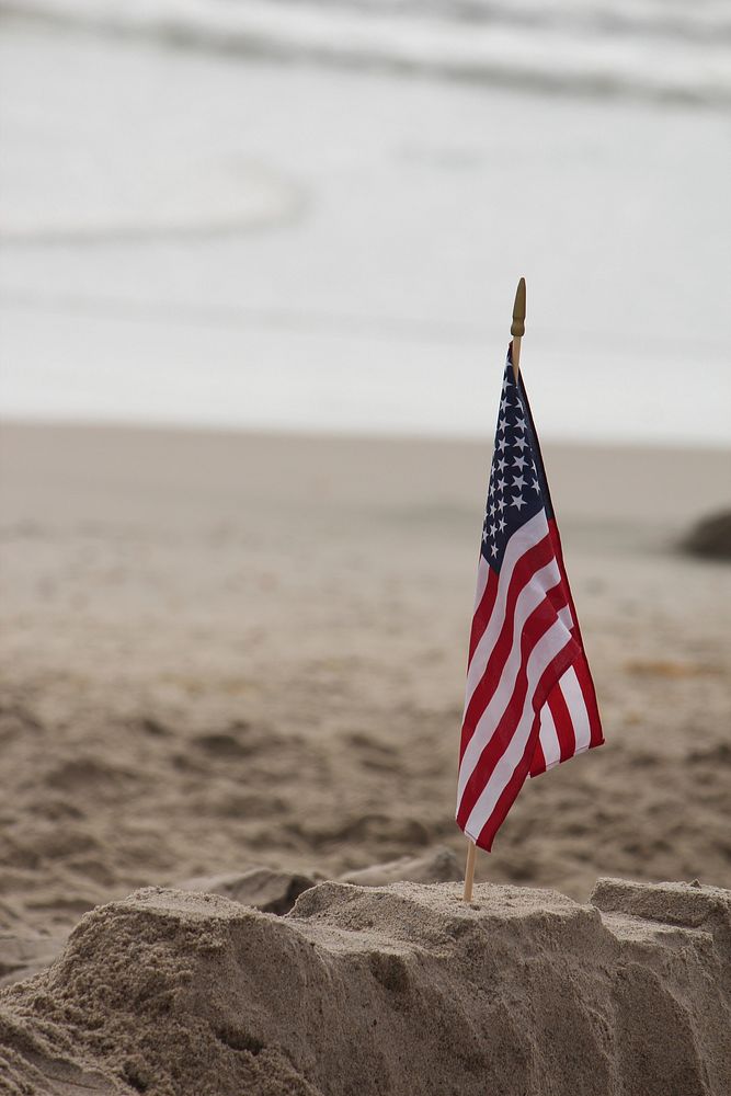 American flag on beach sand. Free public domain CC0 photo.