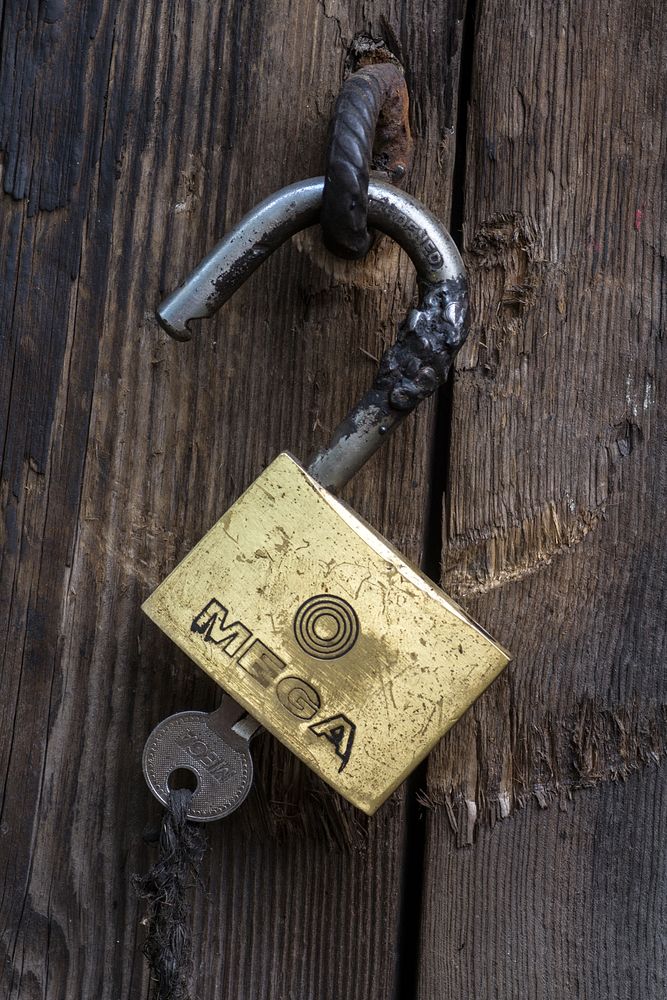 Padlock hanging on wooden door. Free public domain CC0 photo.