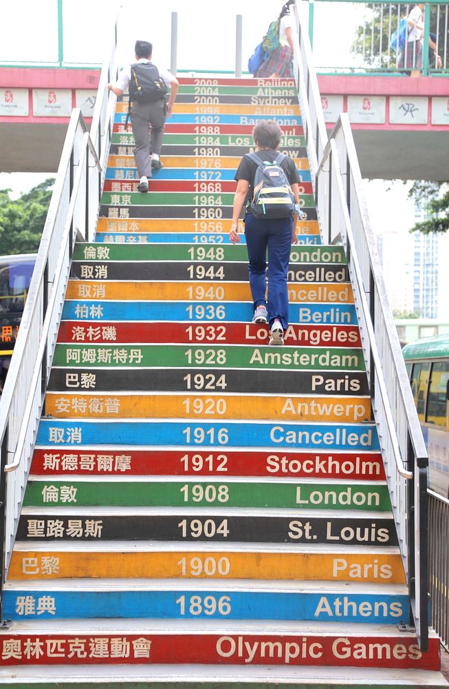 School Children walking up stairs decorated with past Olympic dates in Hong Kong