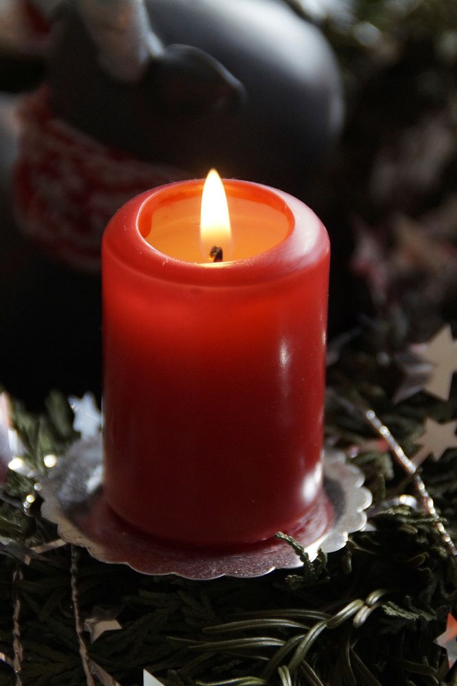 Burning red candle in the dark. Free public domain CC0 image.