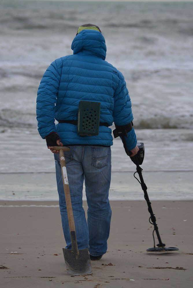 Man with metal detector at the beach. Free public domain CC0 photo.