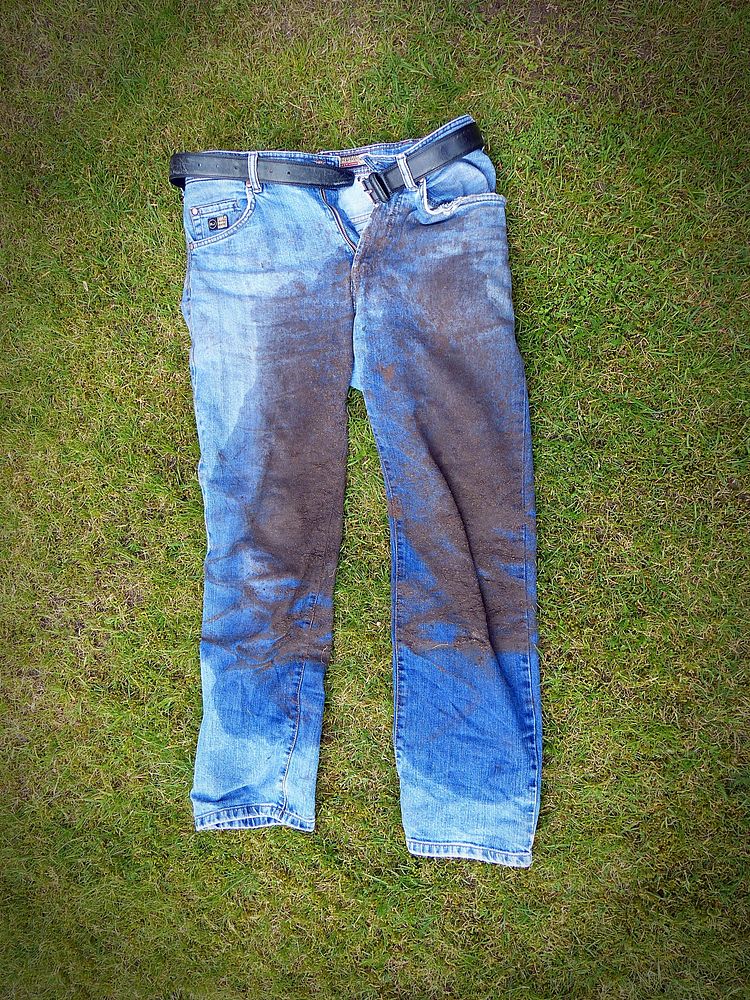 Dirty jeans on grass floor. Free public domain CC0 photo.