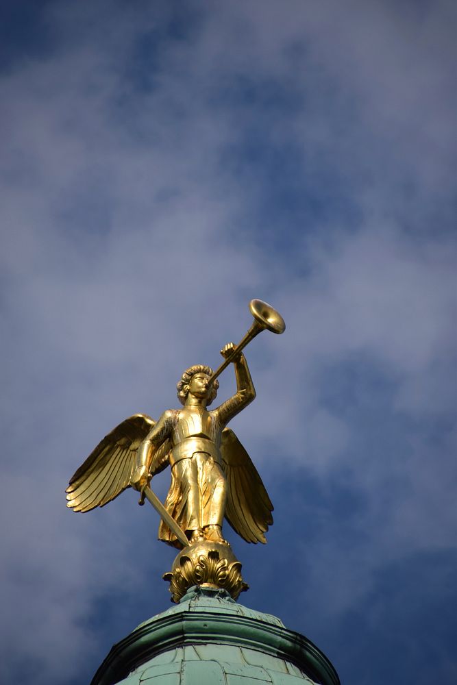 Golden statue on historical church roof. Free public domain CC0 image.