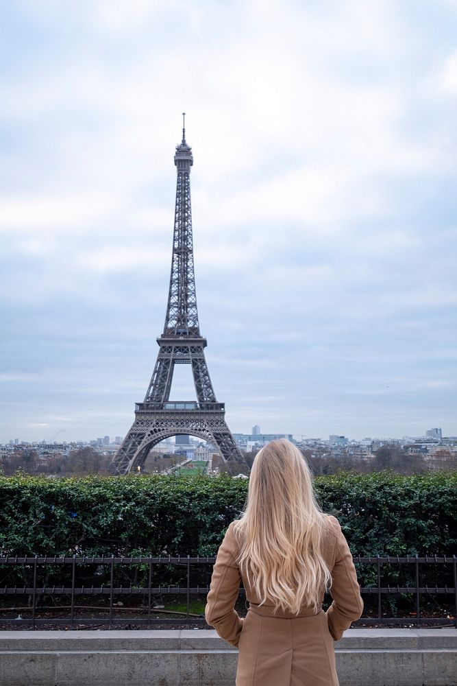Free woman standing and looking towards the Eiffel Tower in Paris photo, public domain building CC0 image.