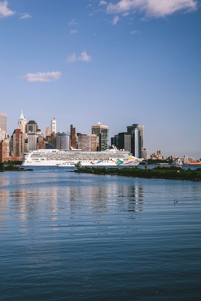 Landscape view of ocean with cruise ship and city skyscrapers as background