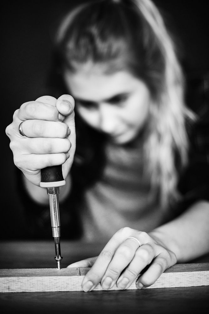 Young woman screwing down a screw